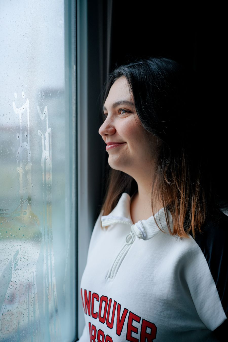 Person blickt nachdenklich aus dem Fenster